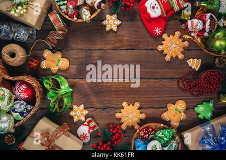 Christmas  background with gingerbread, decorations and gift boxes, balls, toy on vintage old wooden board. Beautiful xmas frame. Idea for advertising Stock Photo