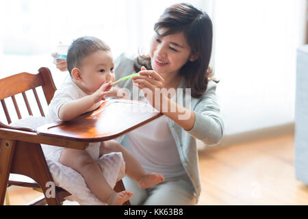 Young Chinese mother feeding baby Stock Photo