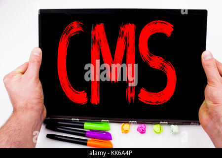 CMS text written on tablet, computer in the office with marker, pen, stationery. Business concept for CMS WWW white background with space Stock Photo