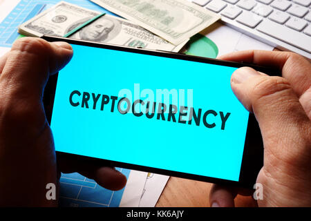 Cryptocurrency concept. Smartphone, financial graphs and money. Stock Photo