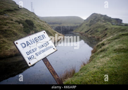 Danger sign - deep water by an abandoned quarry pool, Shropshire UK Stock Photo