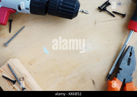 Tools for home renovation on a wooden desk. Hammer, screws and screwdriver. Stock Photo
