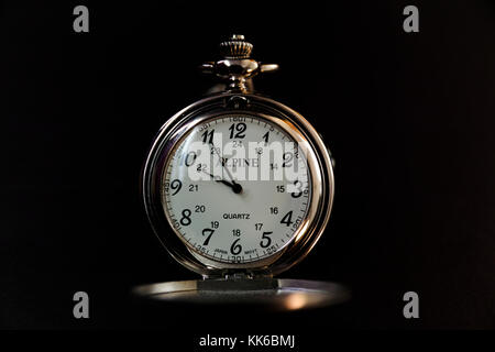 An Alpine Quartz pocket watch set against a black background Stock