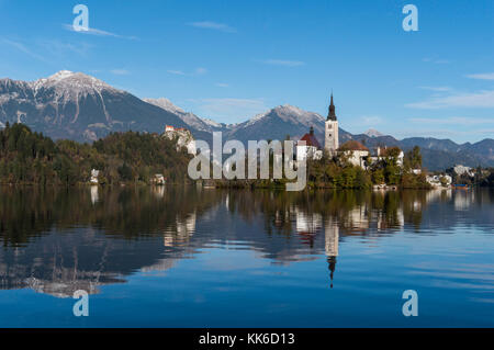 Church, castle and mountains reflecting into the clear, pure waters of Lake Bled in Slovenia Stock Photo