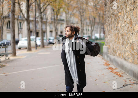 Sad mix blood man going to railway station and looking at watch. Stock Photo