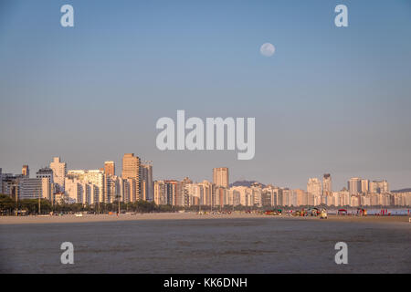 Santos Beach and city skyline at sunset with full moon - Santos, Sao Paulo, Brazil Stock Photo