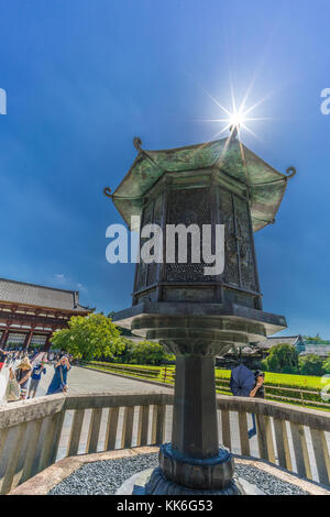 Nara, Japan - August 24, 2017 : Sunstar, Hakkaku-toro, National Treasure Octagonal bronze lantern in front of Daibutsuden at Todai-ji Temple Complex.  Stock Photo