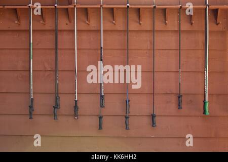 ski poles hanged against wooden wall Stock Photo