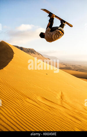 Sandboarding on Caramucho dunes, in Atacama Desert. Iquique, Tarapaca Region, Chile. Stock Photo