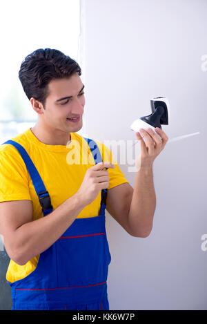 Contractor installing surveillance CCTV cameras in office Stock Photo
