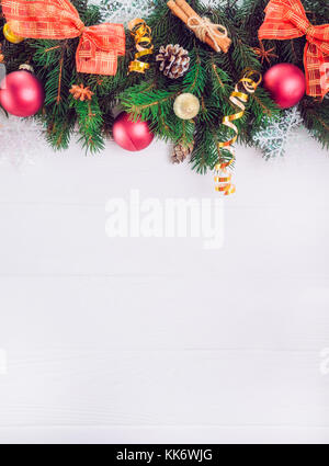 Christmas background with fir branches, new year decor, toys and spices on the white wooden backdrop. Top view with copy space. Selective focus Stock Photo