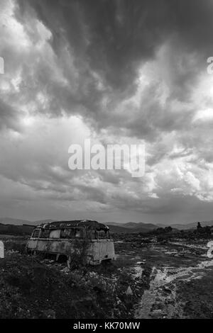 Old abandoned bus wreck in black and white contrast sky Stock Photo