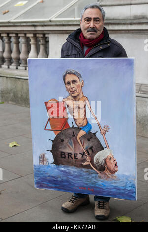 London, UK. 22nd November, 2017. Satirical artist Kaya Mar stands outside Downing Street with an artwork of Philip Hammond MP, Chancellor of the Exche Stock Photo
