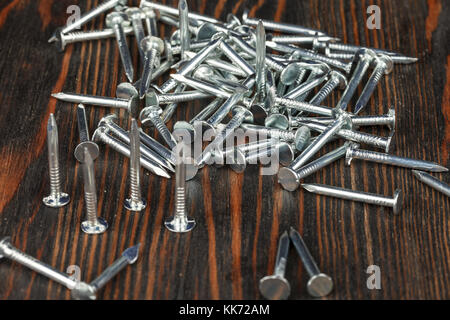 Construction nails on a wooden surface. Close-up. Studio lighting. Stock Photo