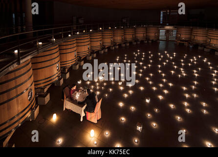 Couple having a romantic dinner in the fermentation room of Clos Apalta winery. Colchagua Valley, Chile. Stock Photo