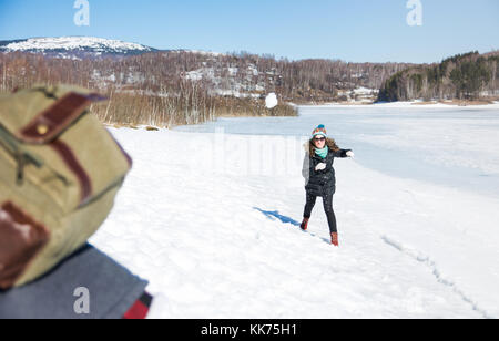 Couple snowball fighting and having fun on a frozen lake Stock Photo