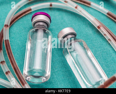 Rubber drip irrigation system with traces of blood along with vial, conceptual image Stock Photo
