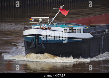 Bow of inland vessel running at high speed with two anchors and white foaming bow wave Stock Photo