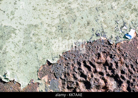Rust breaks through aged green paint covering the old aged metal beneath the surface copy space area for repair renovation ideas and designs Stock Photo
