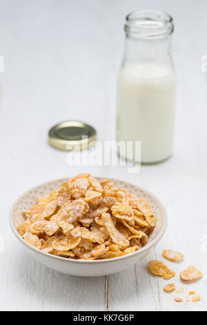Cornflakes in a bowl and milk bottle. Stock Photo