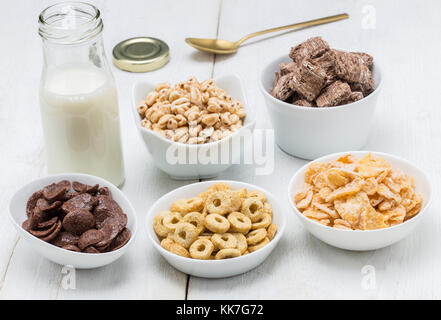 Various conrflake cereals in bowls and milk. Stock Photo