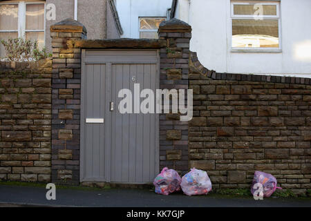 Pink bags used for the household recycling of plastics and bins used for the recycling of food Stock Photo