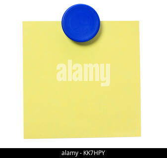 Yellow adhesive note and blue magnet button on whiteboard. Stock Photo