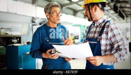 Engineer Teaching Apprentices To Use Computerized cnc metal processing machines Stock Photo