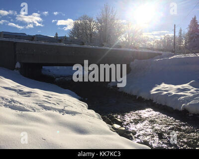Snow covered banks line each side of High Creek as the icy water runs quickly through the newly built Fish Culvert under SR 542 on Tuesday, Dec. 13, 2016. High Creek and December Snow 30856867093 o Stock Photo