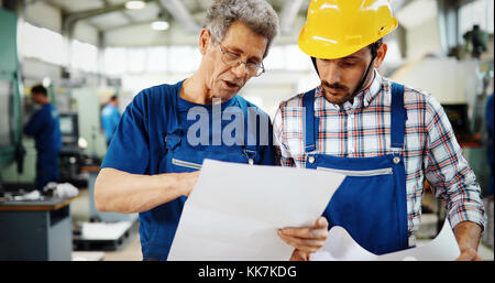 Engineer Teaching Apprentices To Use Computerized cnc metal processing machines Stock Photo