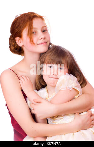 Two sisters holding together wearing holiday dresses isolated Stock Photo