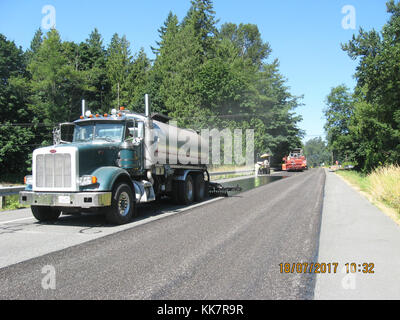 In 2018 WSDOT contractor crews from Granite Construction put a new surface on SR 20 between Sedro-Woolley and Concrete. The new surface is put down over the existing road (once road repair and crack sealing is done) to help protect the road from weather and traffic wear-and-tear. This work is much less expensive than paving and extends the life of the current pavement however, unlike paving, it does not create a new pavement surface for drivers, just coats the surface that is already there. SR 20 resurfacing 36920678216 o Stock Photo