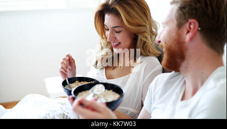 Young attractive couple having breakfast in bed Stock Photo