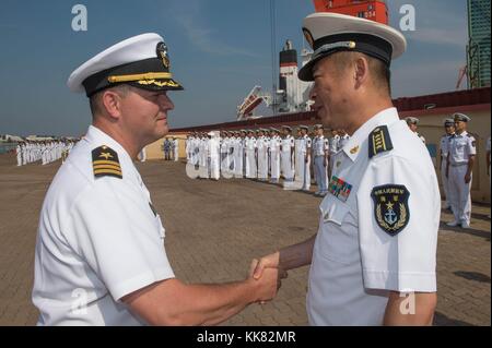 Commander Harry Marsh, left, commanding officer of the Arleigh Burke-class guided-missile destroyer USS Stethem DDG 63, bids farewell to Peoples Liberation Army Navy Senior Capt, Qingdao, China. Image courtesy Mass Communication Specialist 3rd Class Kevin V. Cunningham/US Navy, 2015. Stock Photo