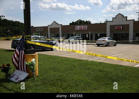 Police tape and a makeshift memorial frame the scene at an Armed Forces Career Center, where earlier in the day an active shooter opened fire, injuring one US Marine. The gunman later moved to the nearby Navy Operational Support Center (NOSC) firing multiple shots, killing four Marines and injuring one Sailor. (U.S. Navy photo by Damon J. Moritz/Released), 2015. Stock Photo