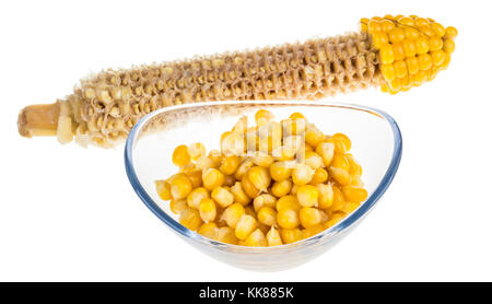 Yellow boiled corn isolated on white background. Partly eaten corncob and pile of corn grains in glass bowl. Stock Photo