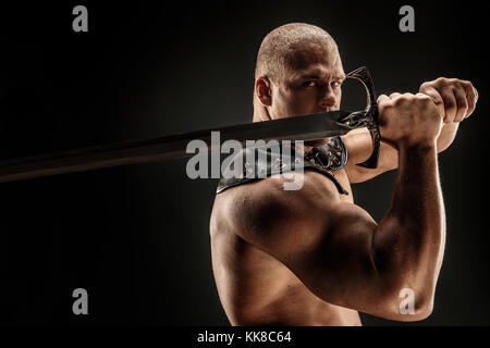 Severe barbarian in leather costume with sword Stock Photo