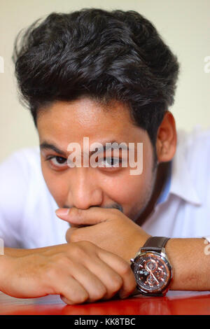 Young smart casual man covering his face with newspaper while sitting ...