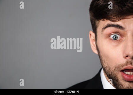 Cropped portrait surprised brunette man looking at camera, isolated on gray background Stock Photo