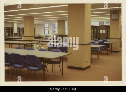 An photograph of the reading room located in the Mid-Manhattan Library, it is a branch of the New York Public Library which was opened in 1970, it contains the largest collection of circulating books in the NYPL system, the library is focused on works for students and adults, New York, 1970. From the New York Public Library. Stock Photo