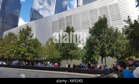 A photograph of the exterior of the National September 11 Museum, the museum was opened to the public in 2014 and houses images and artifacts of the September 11 attack as well as oral histories of the people killed in the attacks, the image captures people congregated outside of the museum and around one of the pools that are part of the National September 11 Memorial, New York, New York, October 17, 2015. Stock Photo