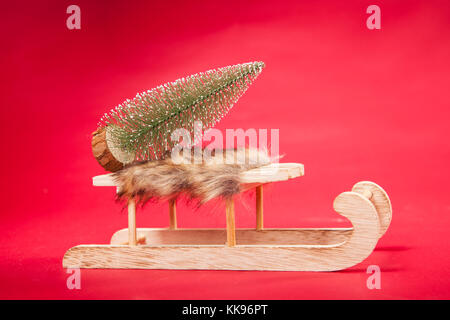 Christmas tree on a sled, red background, copy space Stock Photo