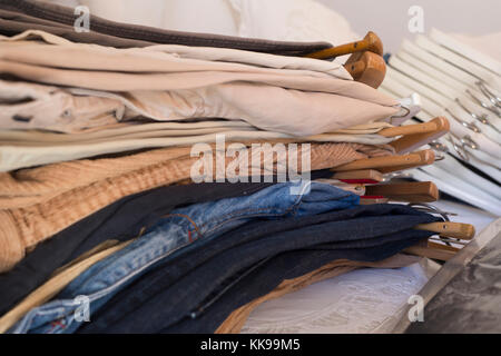 Men's clothes in various colours hanging on hangers Stock Photo