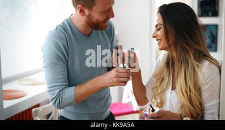 Couple having fun and laughing at home while eating ice cream Stock Photo