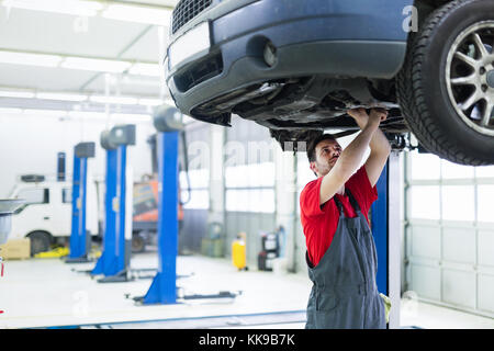 Car mechanic working at automotive service center Stock Photo