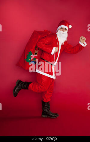 Santa Claus runs with gifts bag Stock Photo