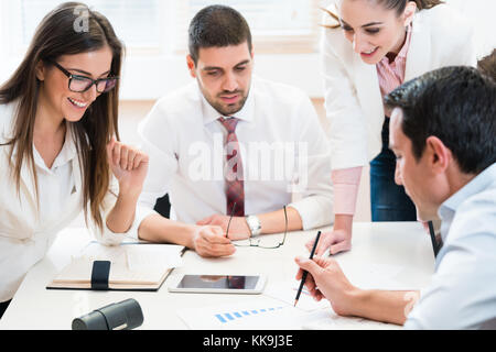 Business team analyzing data and discussing strategy in joint work Stock Photo