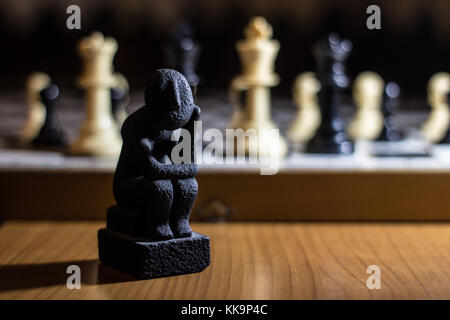 the thinker statue on a chess board coil small thinking about strategy  solution Stock Photo