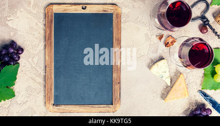 Wine appetizers set: French cheese selection, grapes and walnuts on rustic background. Top view, copyspace Stock Photo