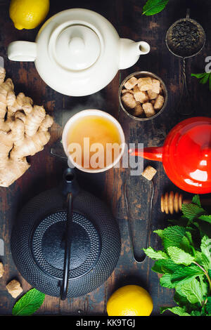 Tea composition on rustic background: tea, mint, lemon, ginger.  Flat lay top view Stock Photo